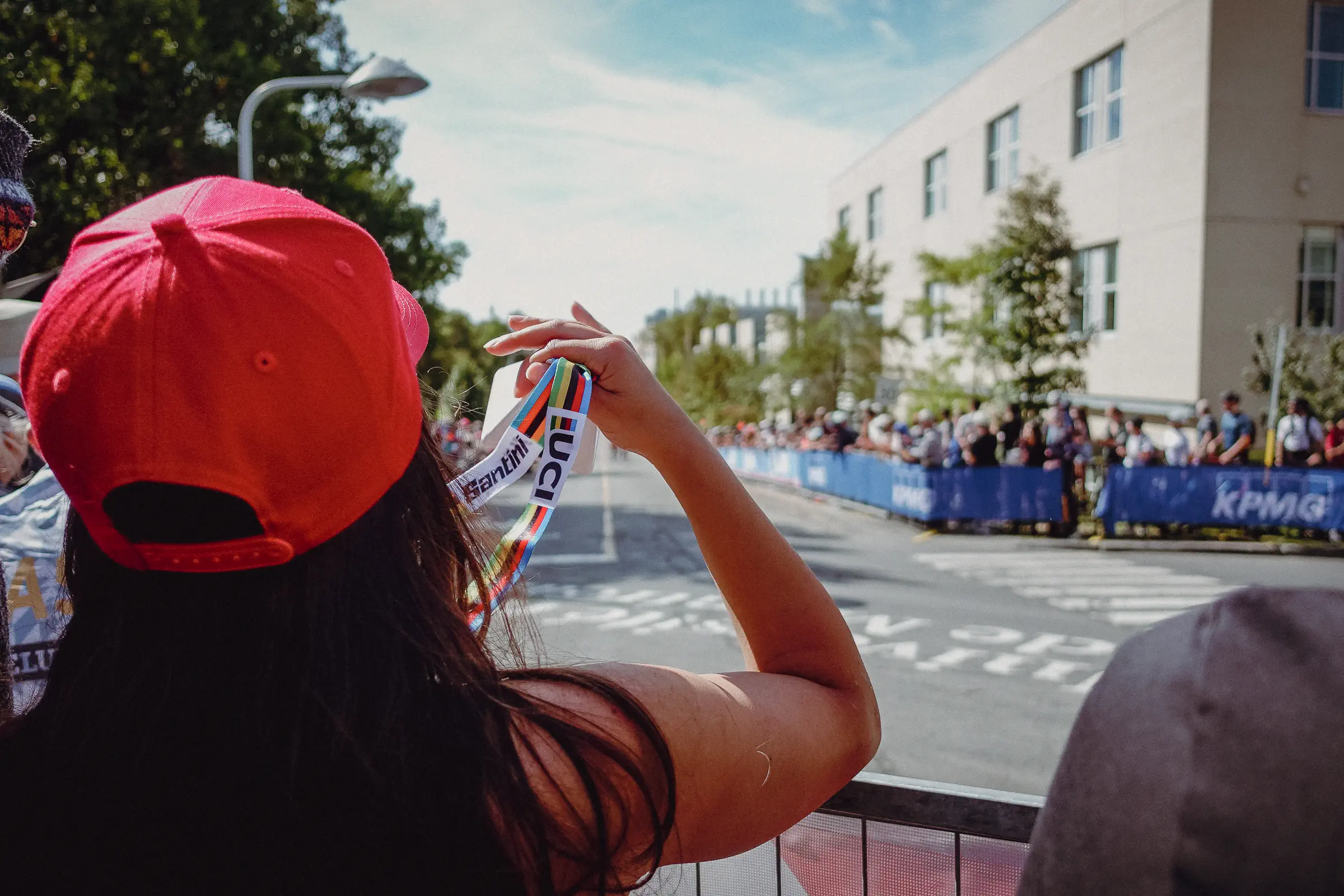 A spectator in a red cap films the course as crowds line both sides of the Montréal road