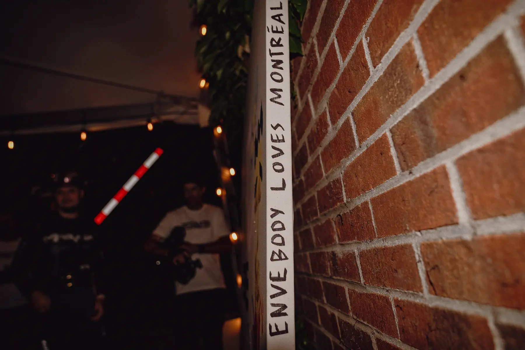 A narrow Montréal doorway carries a glowing “Everybody Loves Montréal” message after dark