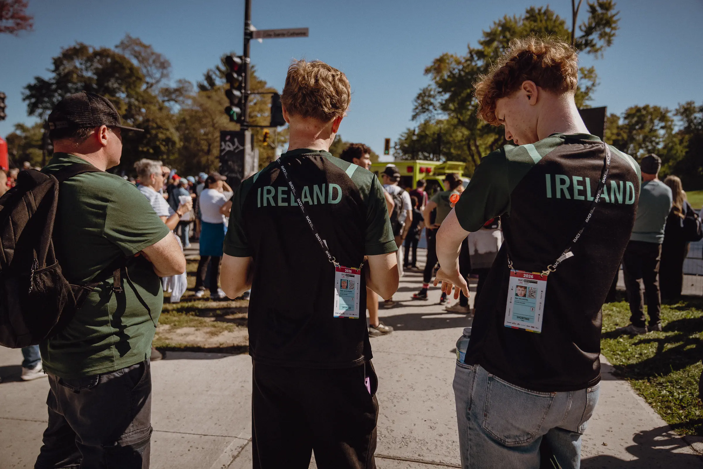 National-team staff stand together at the course edge, watching the final race-day moments unfold