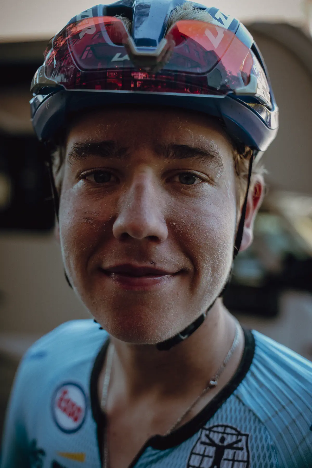 A rider looks directly into the camera in a close, unguarded race-week portrait