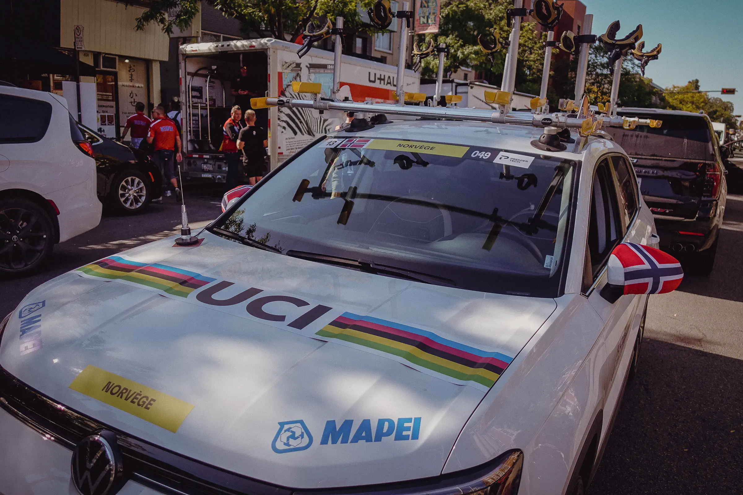 A UCI race car carrying rainbow-band branding sits beside the Montréal course