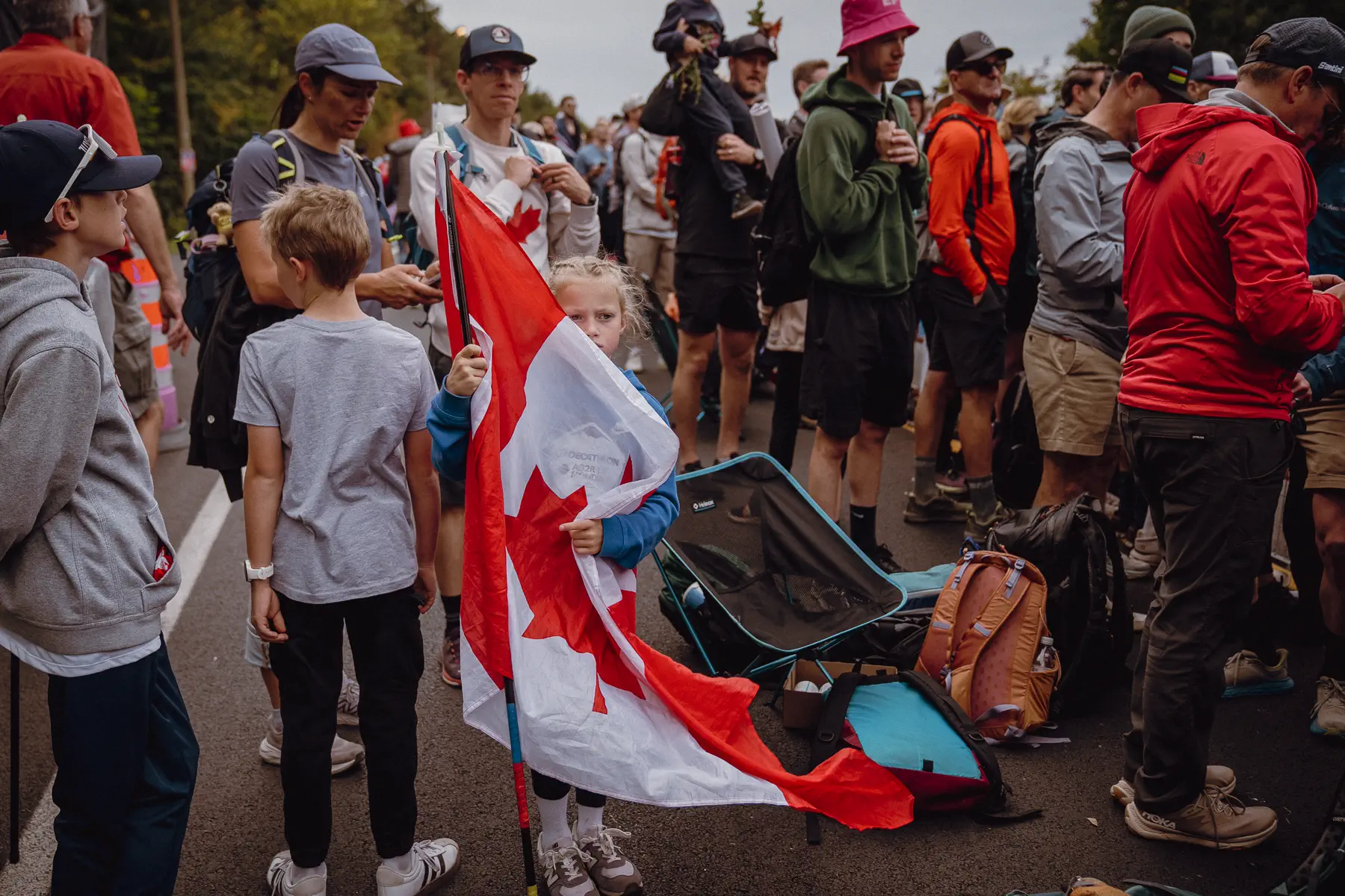 Fans in Canadian colors gather around a large maple-leaf flag beside the Mount Royal course