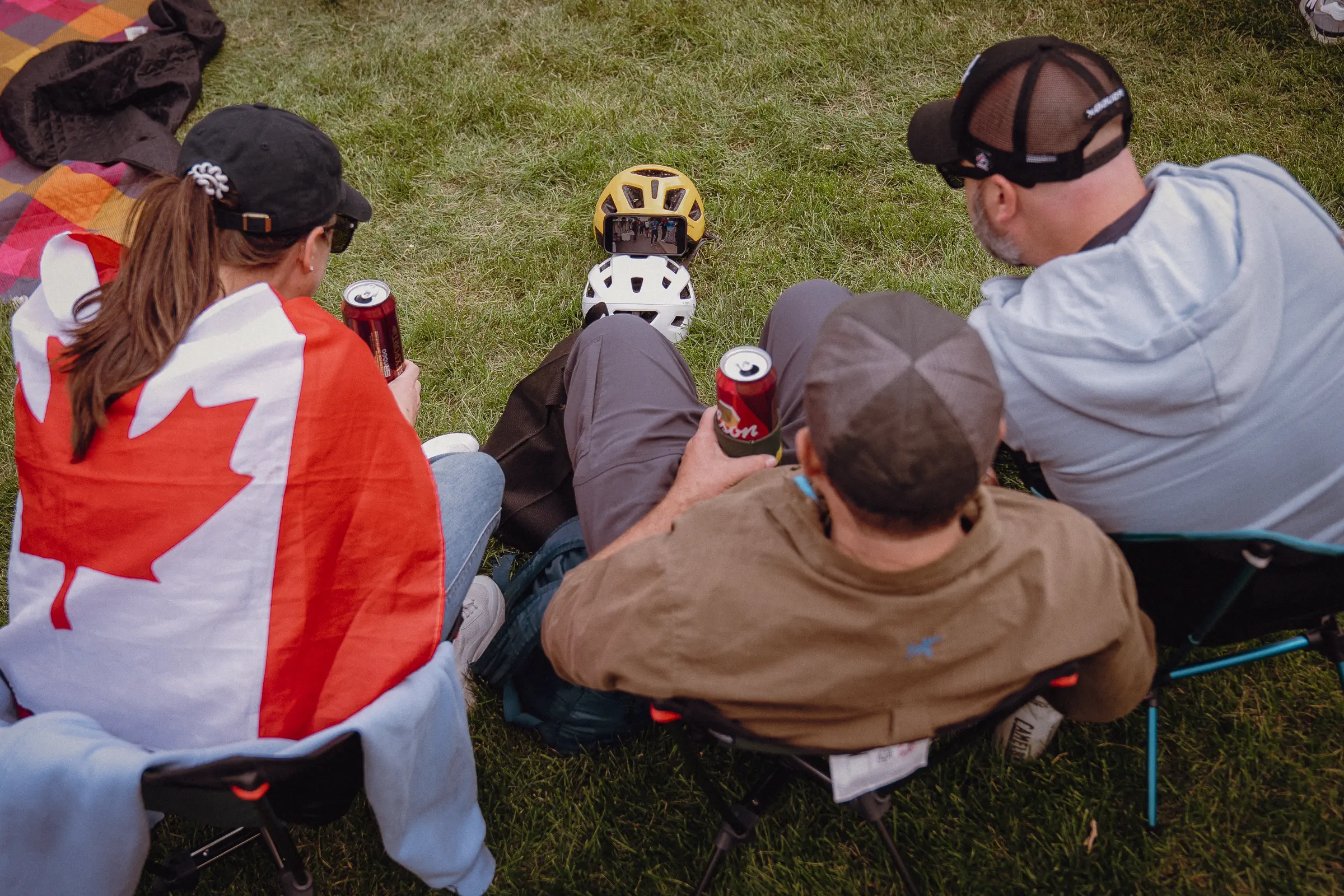 Supporters rest together at the roadside wrapped in Canadian colors as the day starts to settle