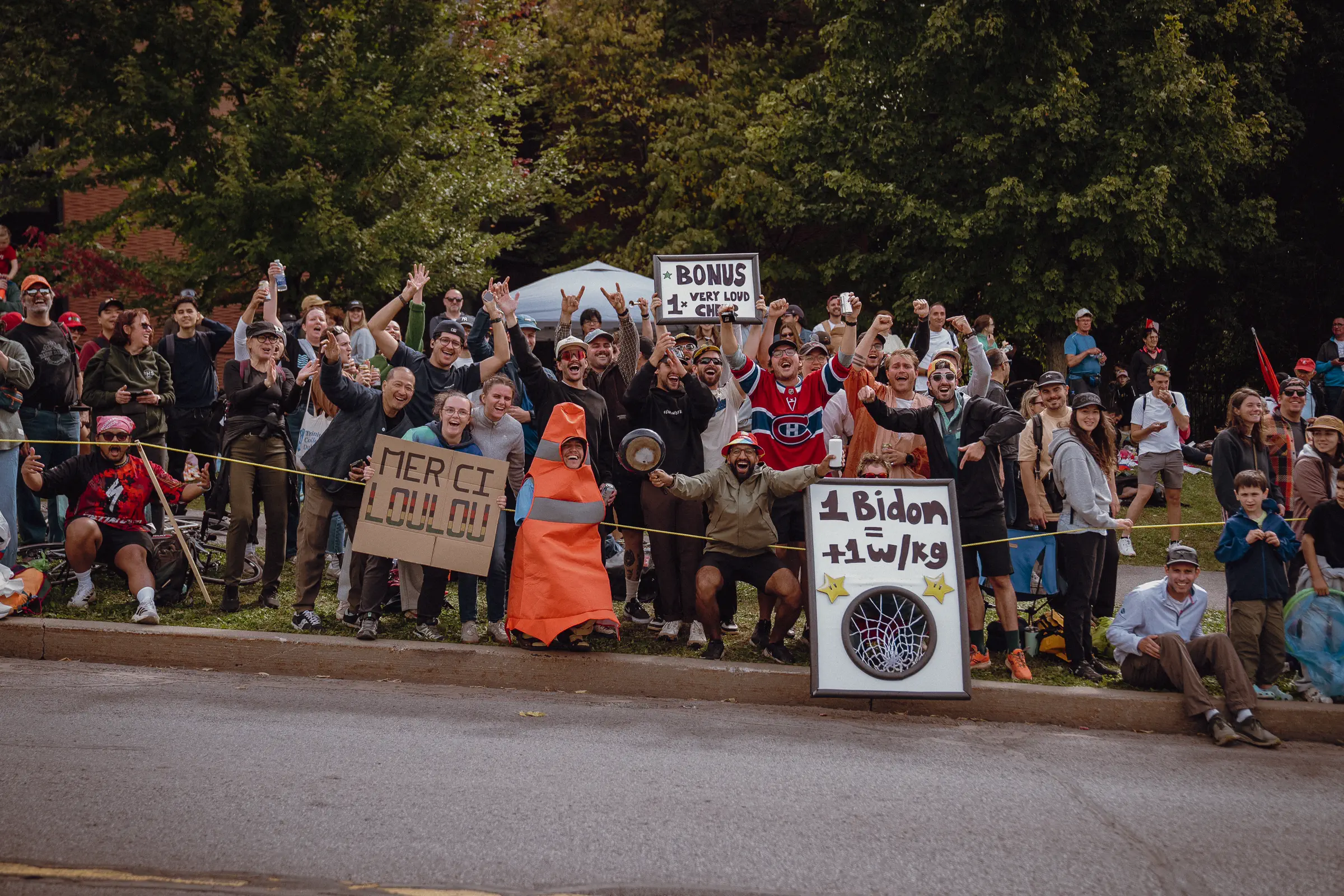 Spectators and handmade signs line the course, holding on to the last moments of the championship atmosphere