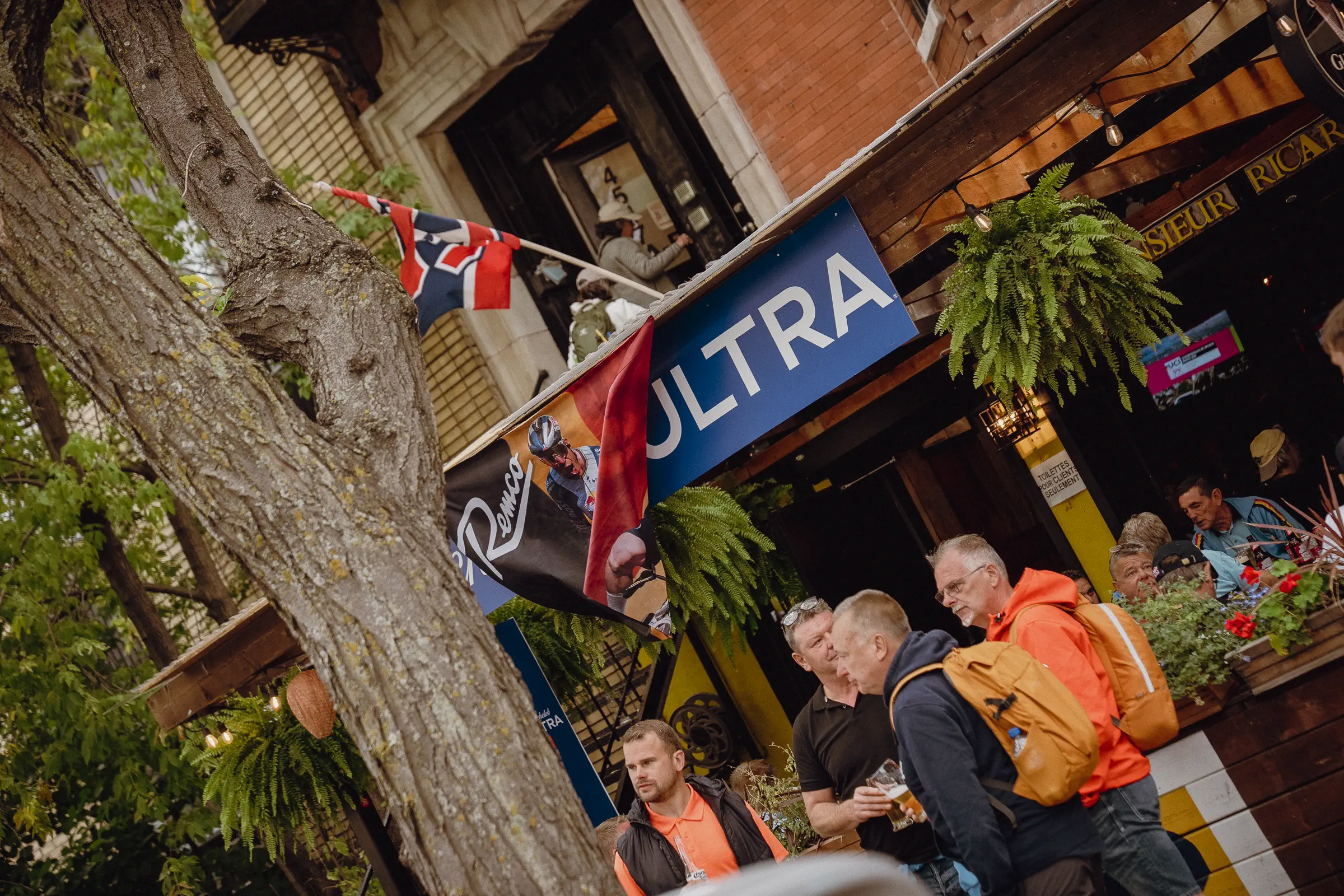 People linger outside a Montréal neighborhood storefront as ordinary city life begins to take over again